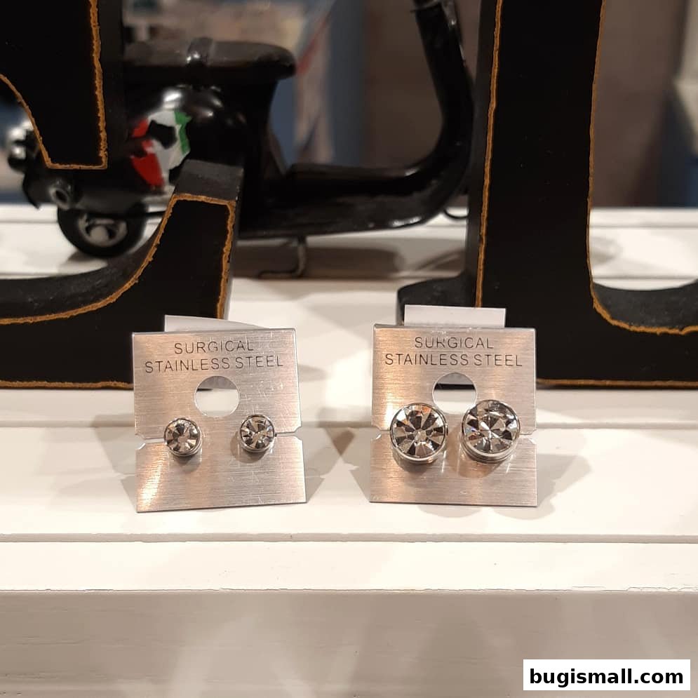 Two pairs of surgical stainless steel earrings with sparkling stones displayed.