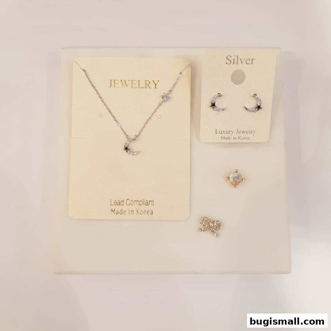 A display of elegant silver jewelry, including a moon-themed necklace and earrings.