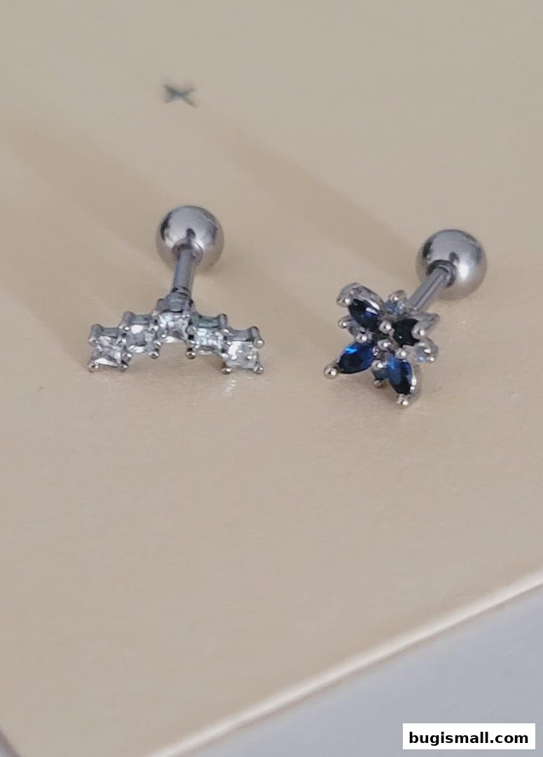 Two delicate silver earrings with sparkling blue and clear stones.