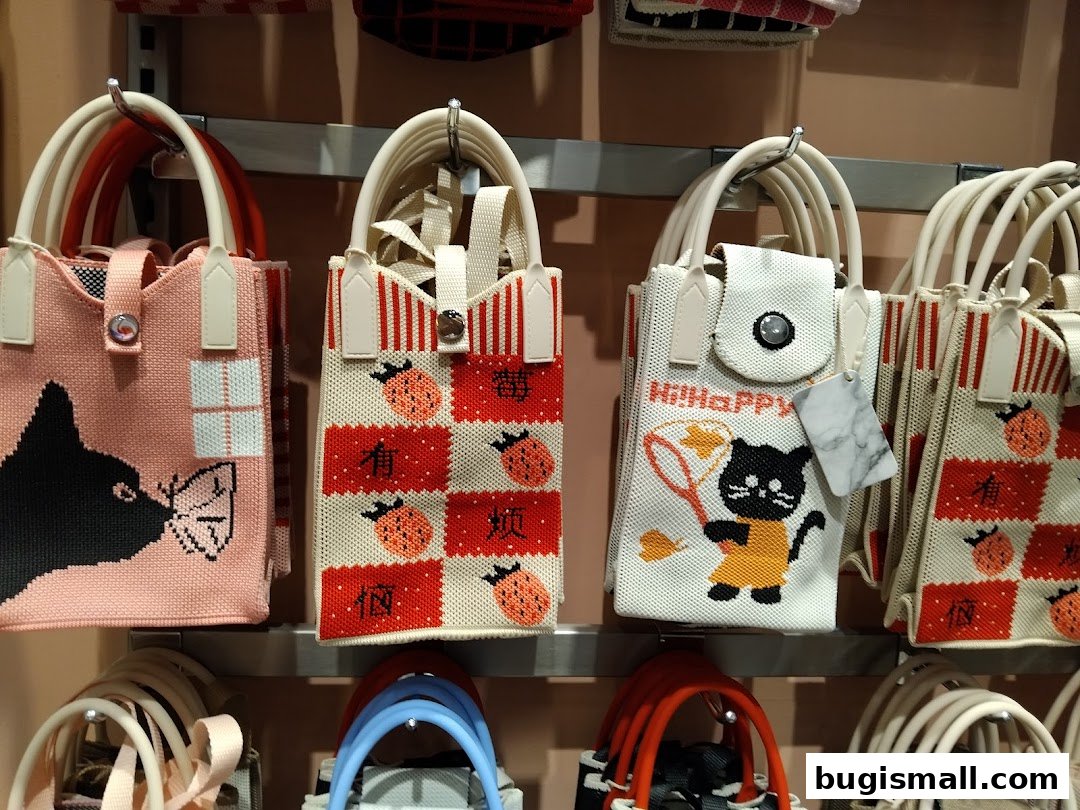 A display of various tote bags with cute animal and fruit designs.