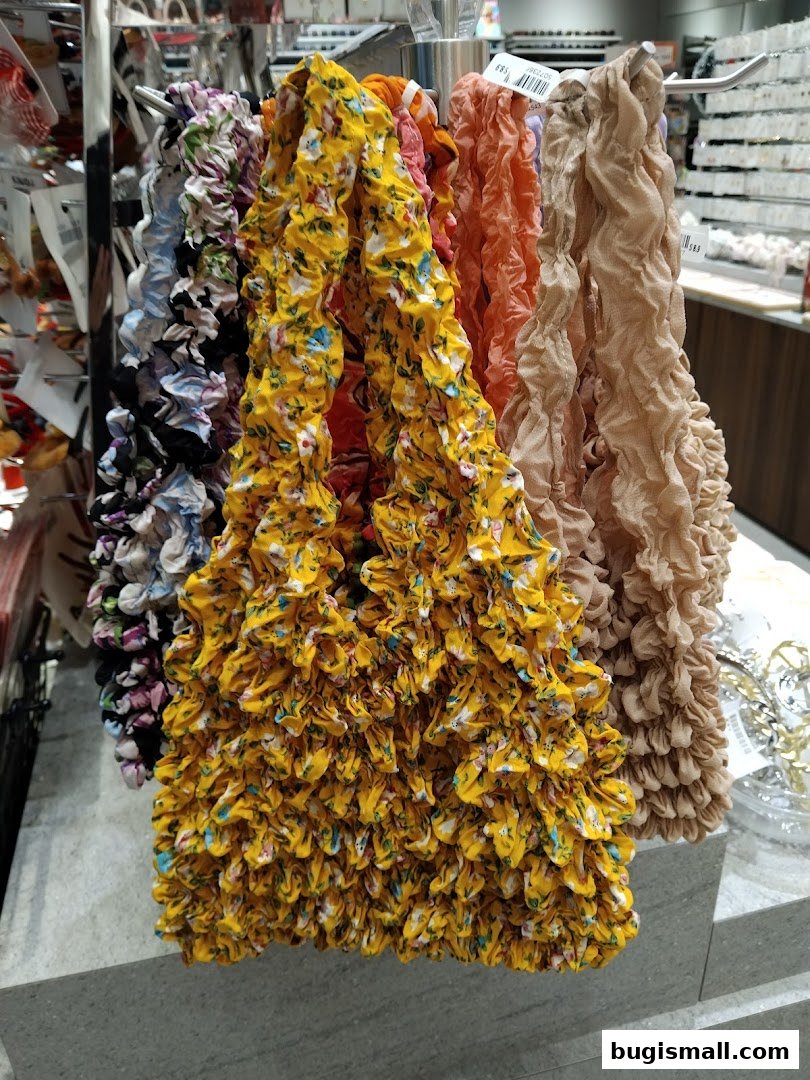 A display of colorful, ruffled scrunchies and hair accessories in a retail store.