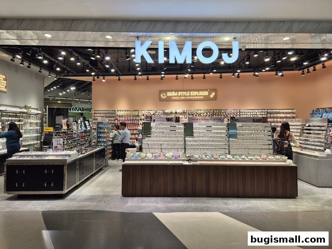 The KIMOJ shop displays a wide variety of jewelry and accessories, with customers browsing the merchandise.