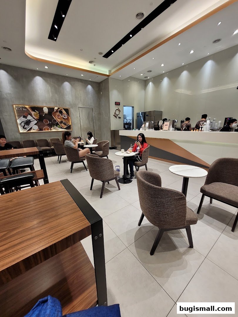 Interior view of KOI Thé Bugis with customers seated and staff behind the counter.