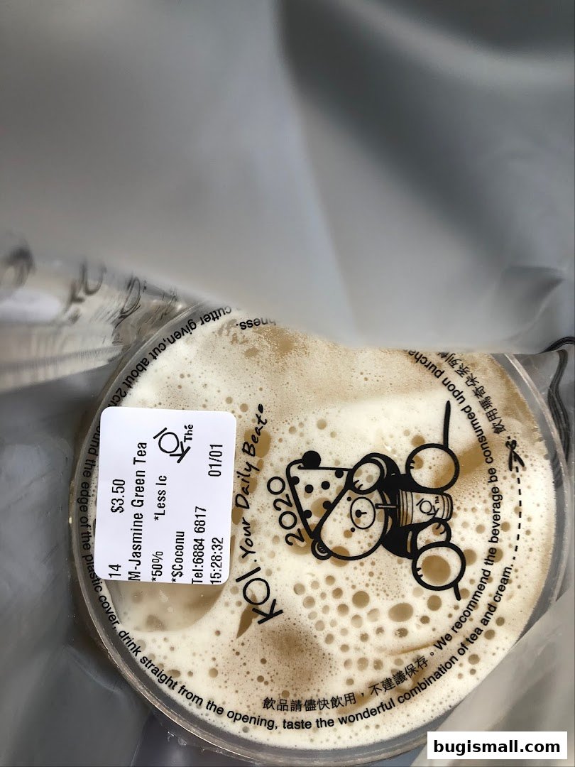 A close-up of a KOI Thé bubble tea with a label showing the drink details and a cute bear logo.