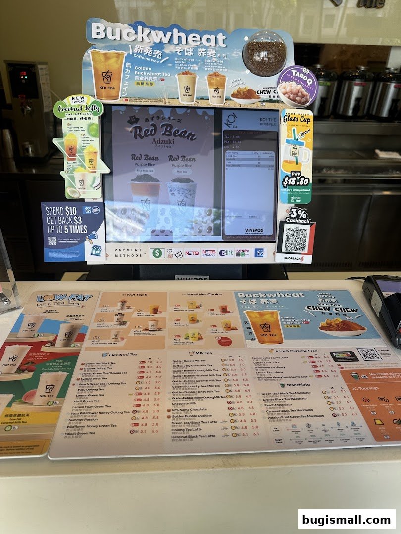 A menu display for KOI Thé featuring various milk teas, flavored teas, and macchiatos.