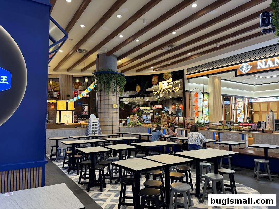 Interior view of a dining area with tables and chairs, showcasing other food stalls in the background.
