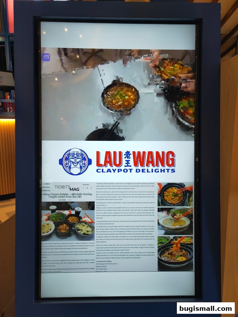 A digital display showcasing Lau Wang Claypot Delights with images of their dishes and a magazine article.