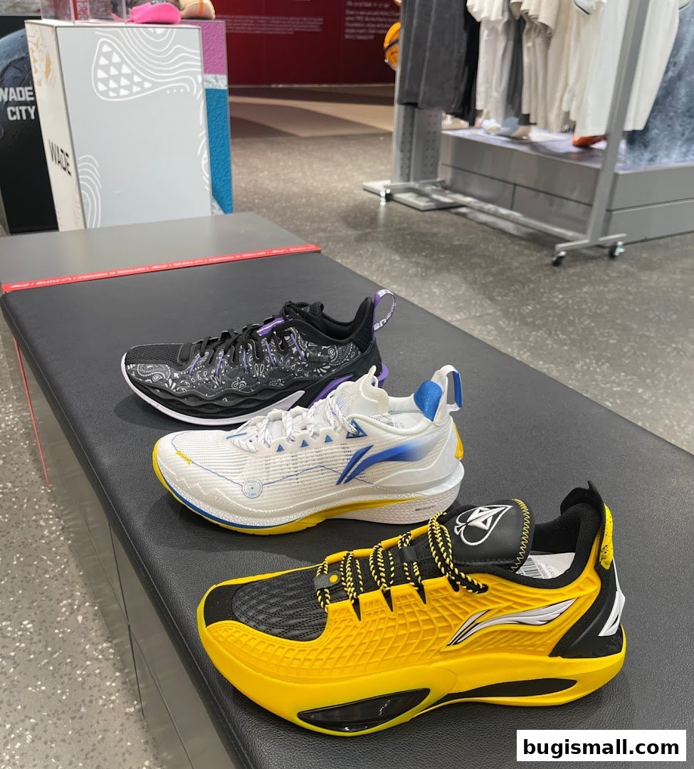 Three stylish Li-Ning sneakers displayed on a bench inside a retail store.