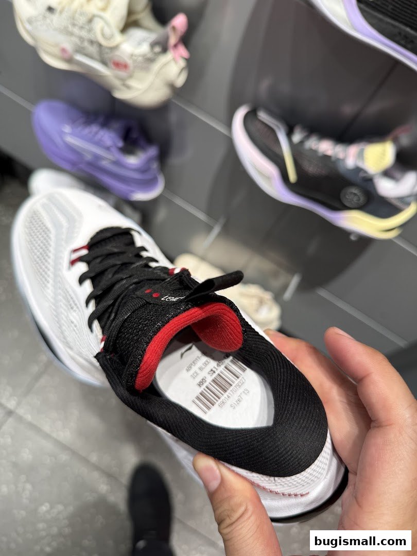 A hand holds a white Li-Ning sneaker with a price tag inside.