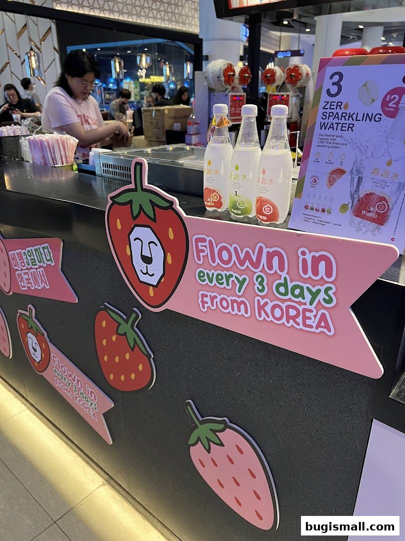 LiHO TEA shop counter with sparkling water bottles and strawberry decorations.
