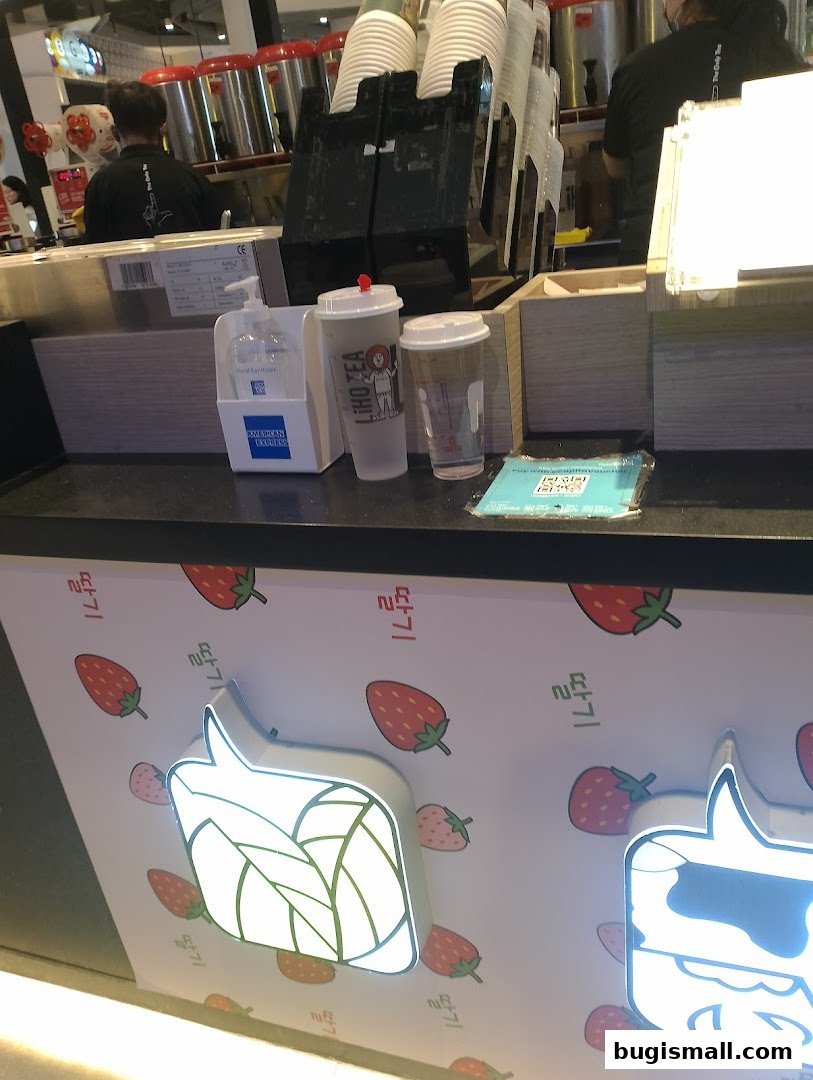 LiHO TEA counter with cups, hand sanitizer, and strawberry-themed decor.