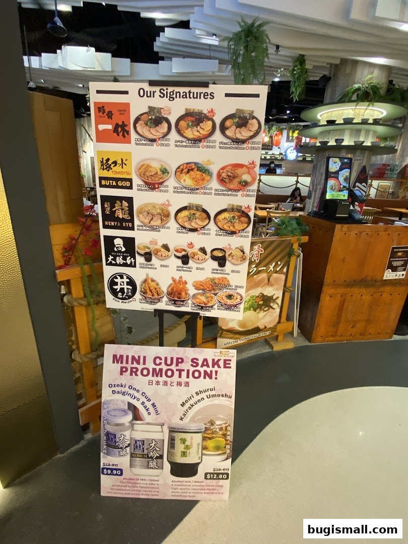 A sign displays signature ramen dishes and a mini cup sake promotion at Marutama Ramen.