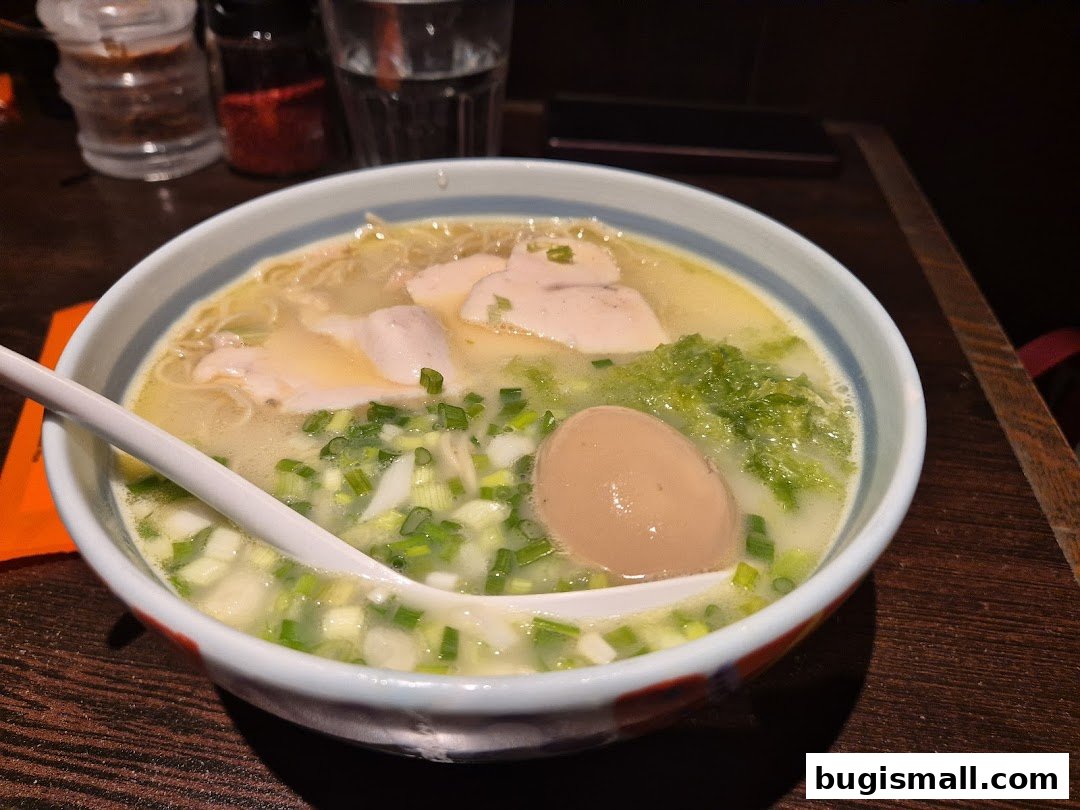 A close-up shot of a delicious bowl of ramen with chicken, egg, and vegetables.
