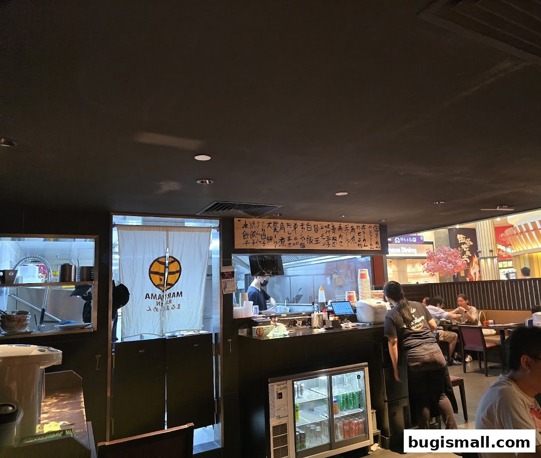 Interior view of Marutama Ramen Bugis with staff and customers dining.