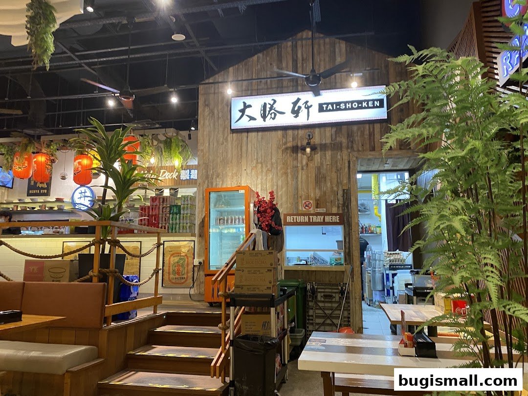 Interior view of a ramen shop with wooden decor, seating, and a view into the kitchen.