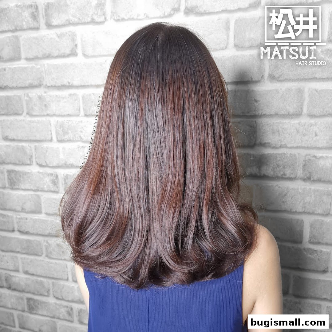 A person with long, wavy brown hair styled by Matsui Hair Studio.
