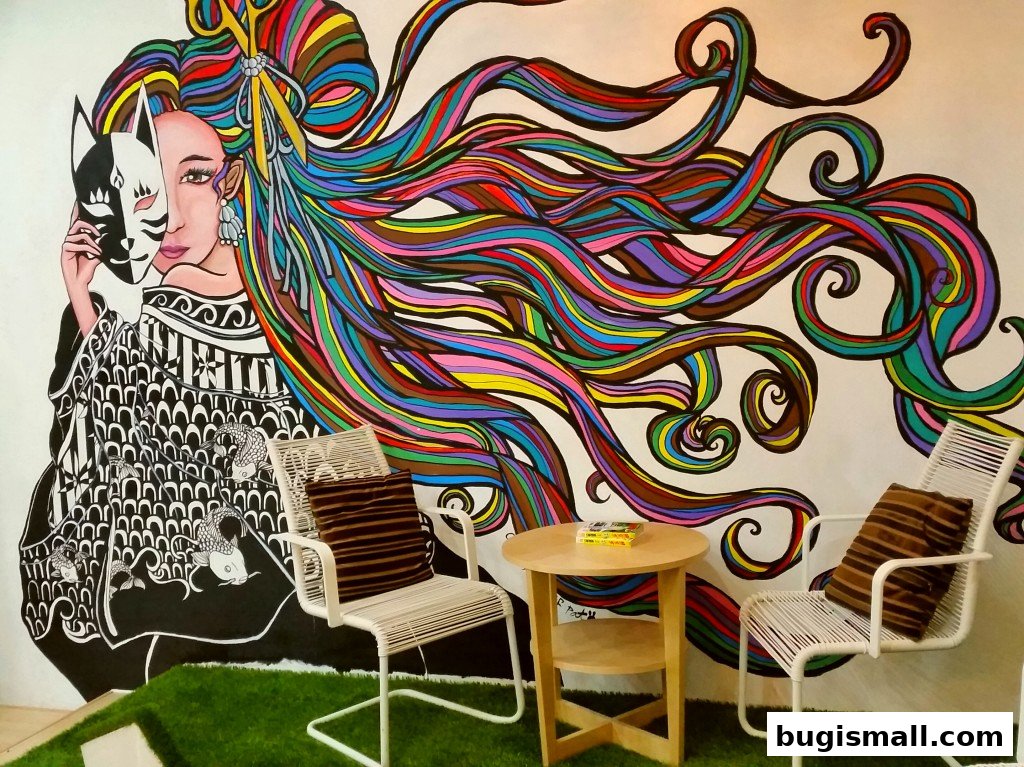 A vibrant mural of a woman with colorful flowing hair and a mask, with chairs and a table.