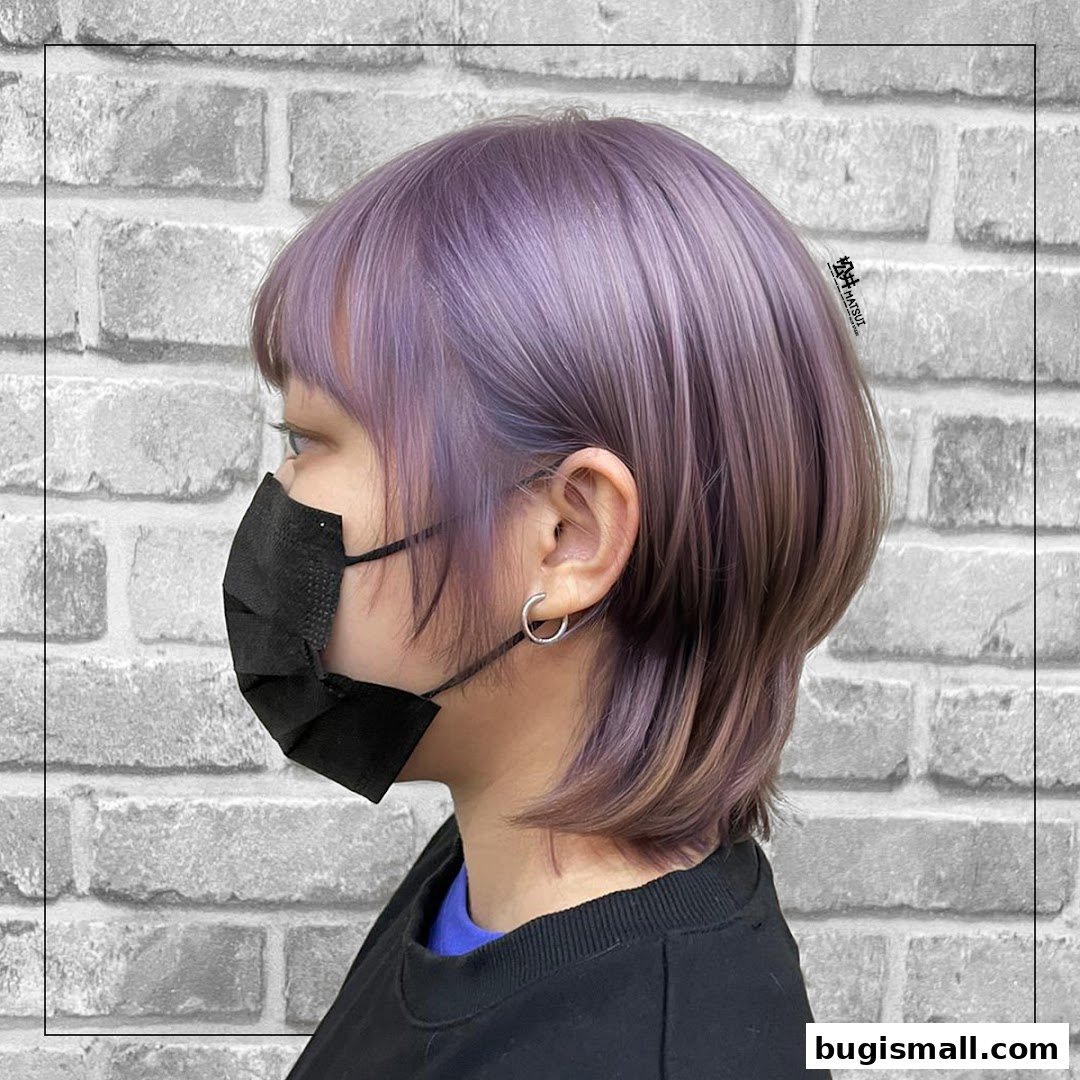 A person with stylish purple and brown layered hair, wearing a black mask and a black shirt.