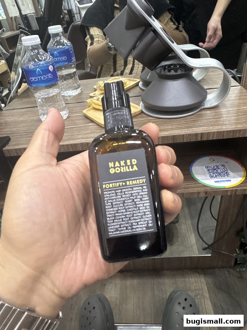 A hand holds a bottle of hair fortifying and remedy product in a hair studio.