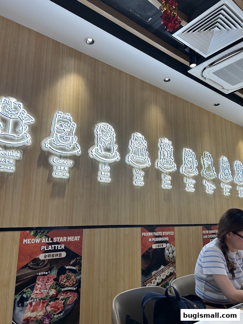 Interior of a restaurant with zodiac signs on the wall and food posters.