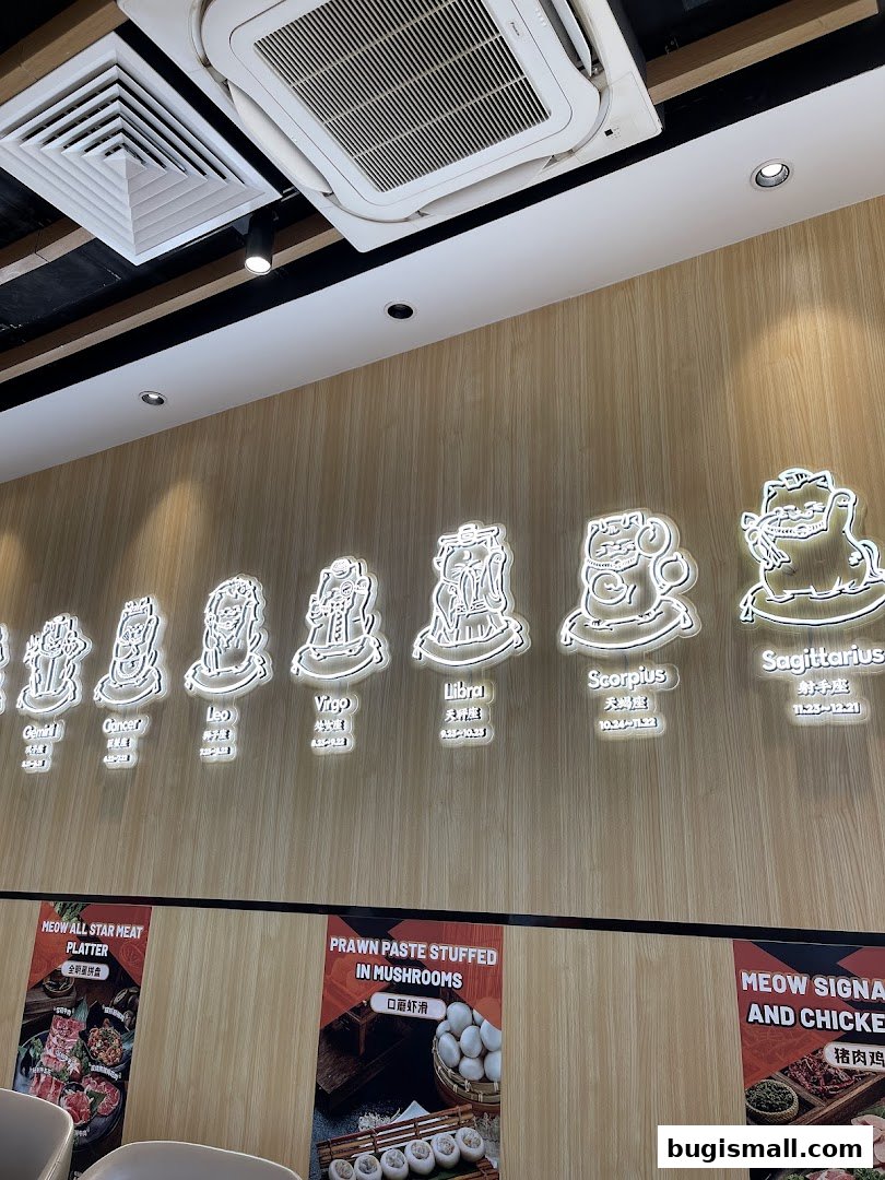 Interior shot of a restaurant with zodiac signs and food promotions on the wall.