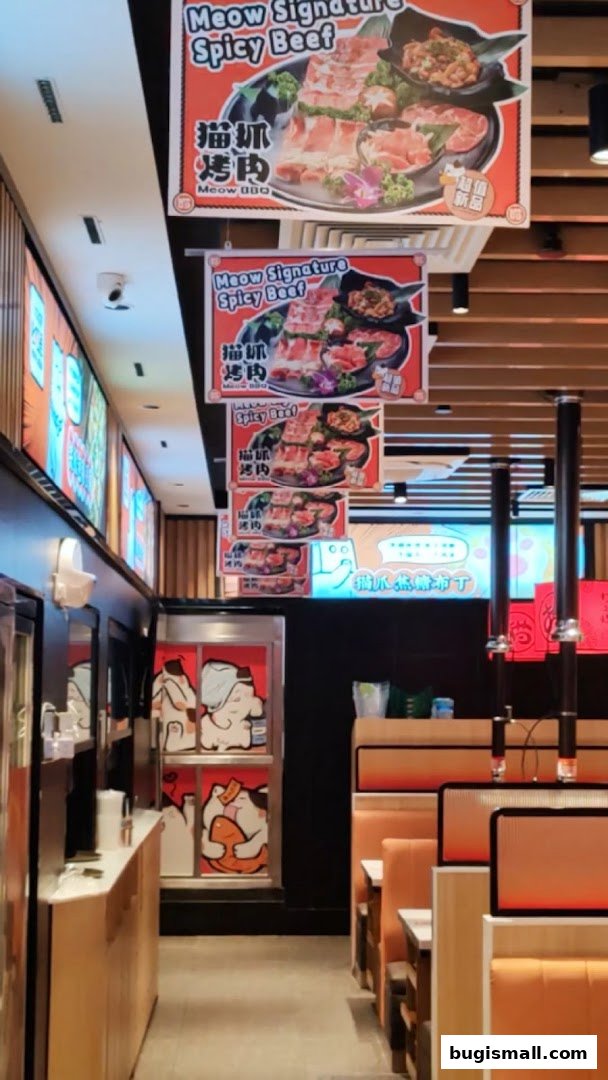 Interior view of Meow Barbecue restaurant with hanging signs and seating.