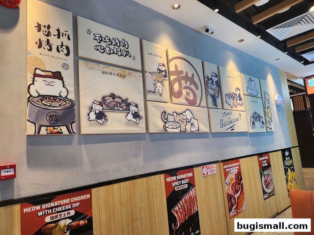 Wall art and posters featuring cartoon cats and barbecue dishes at Meow Barbecue.