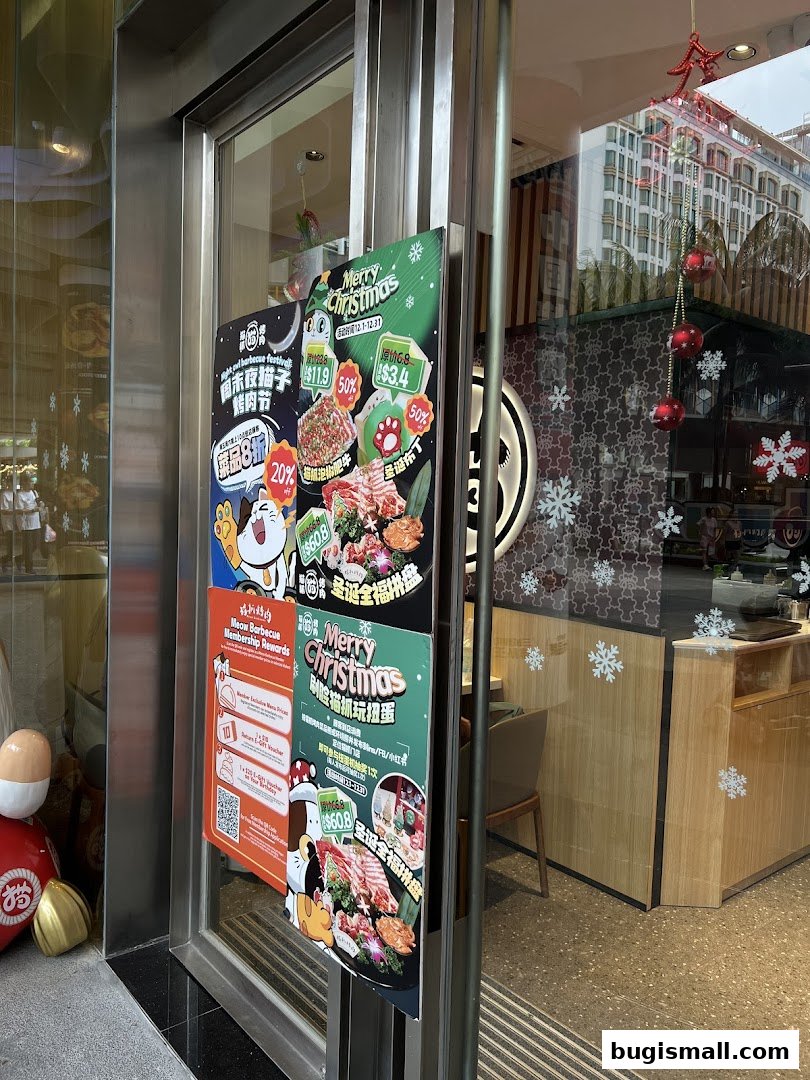 Shop entrance with Christmas promotions and barbecue imagery displayed on the glass door.