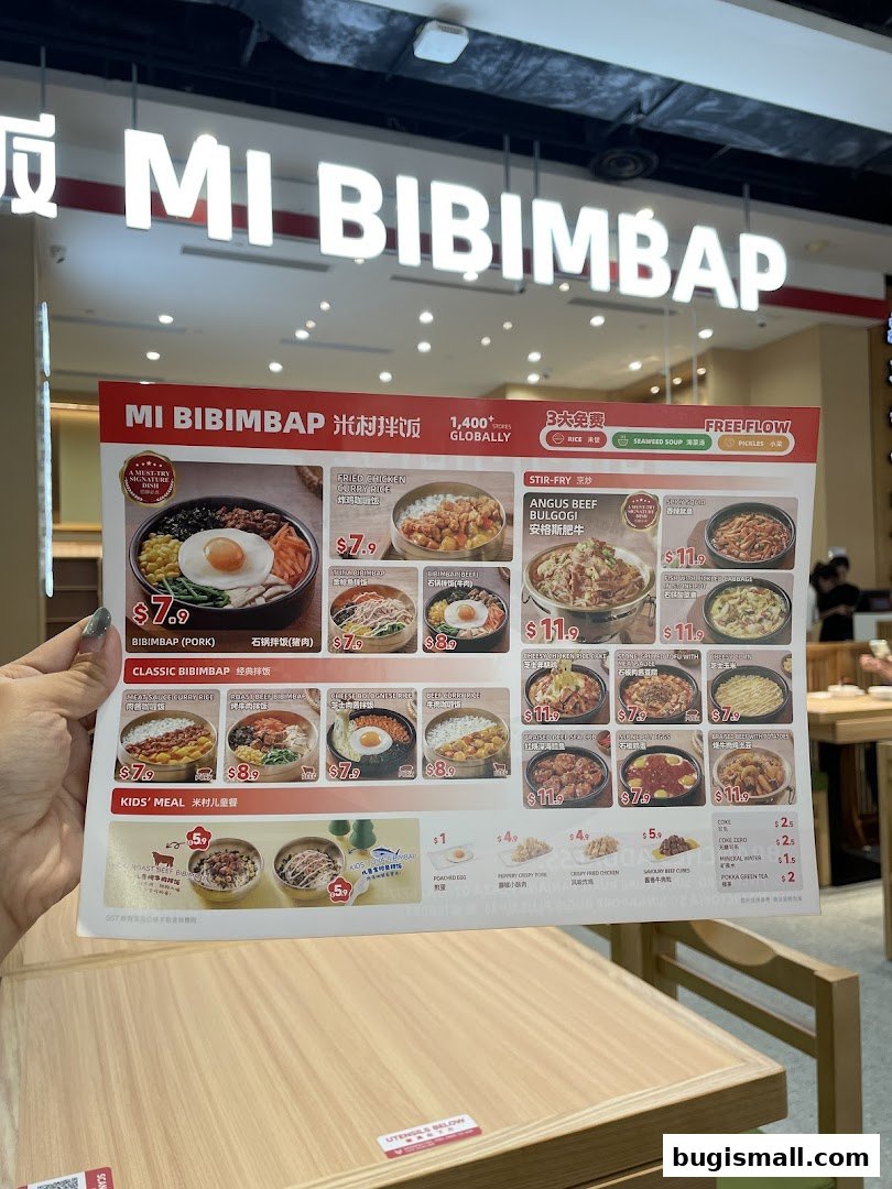 A person holds a menu for Mi Bibimbap, showcasing various Korean dishes and prices.
