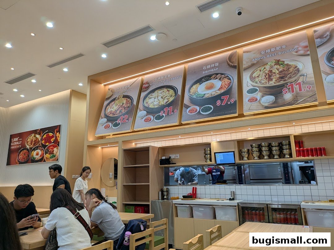Interior of a Korean restaurant with customers and food displays.