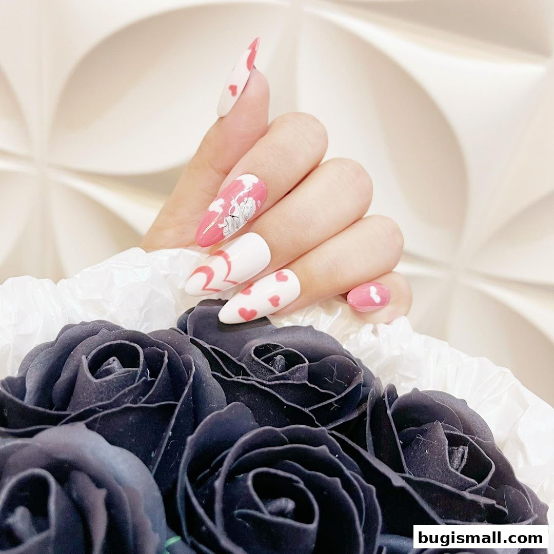 A hand with stylish pink and white nails adorned with hearts and a cartoon character, presented with black roses.