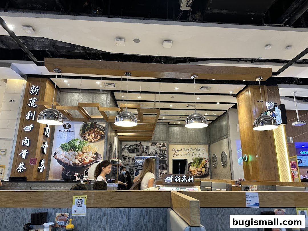 Interior view of New Manlee Bak Kut Teh restaurant with customers and menu displays.