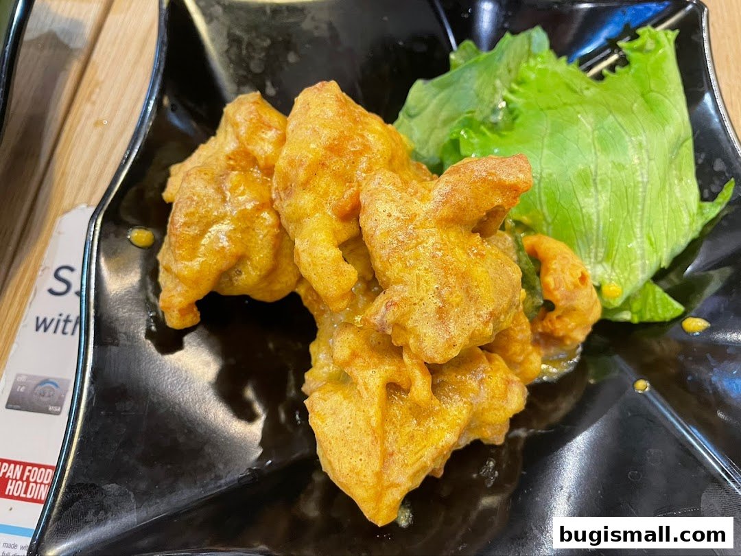 A close-up of crispy, golden-brown fried food with a side of fresh lettuce.