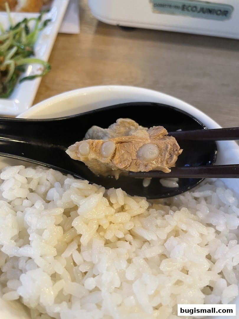 A close-up of tender Bak Kut Teh meat and rice served in a bowl.