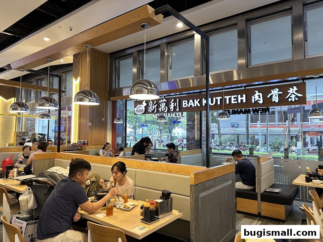 Diners enjoy Bak Kut Teh in a modern restaurant with ample seating and bright lighting.