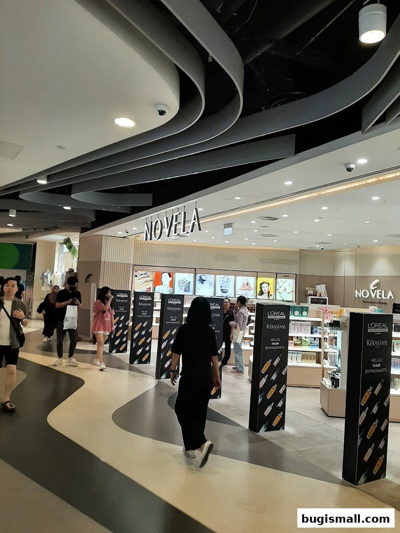 People walk past the Novela beauty store, showcasing L'Oréal and Kérastase products.