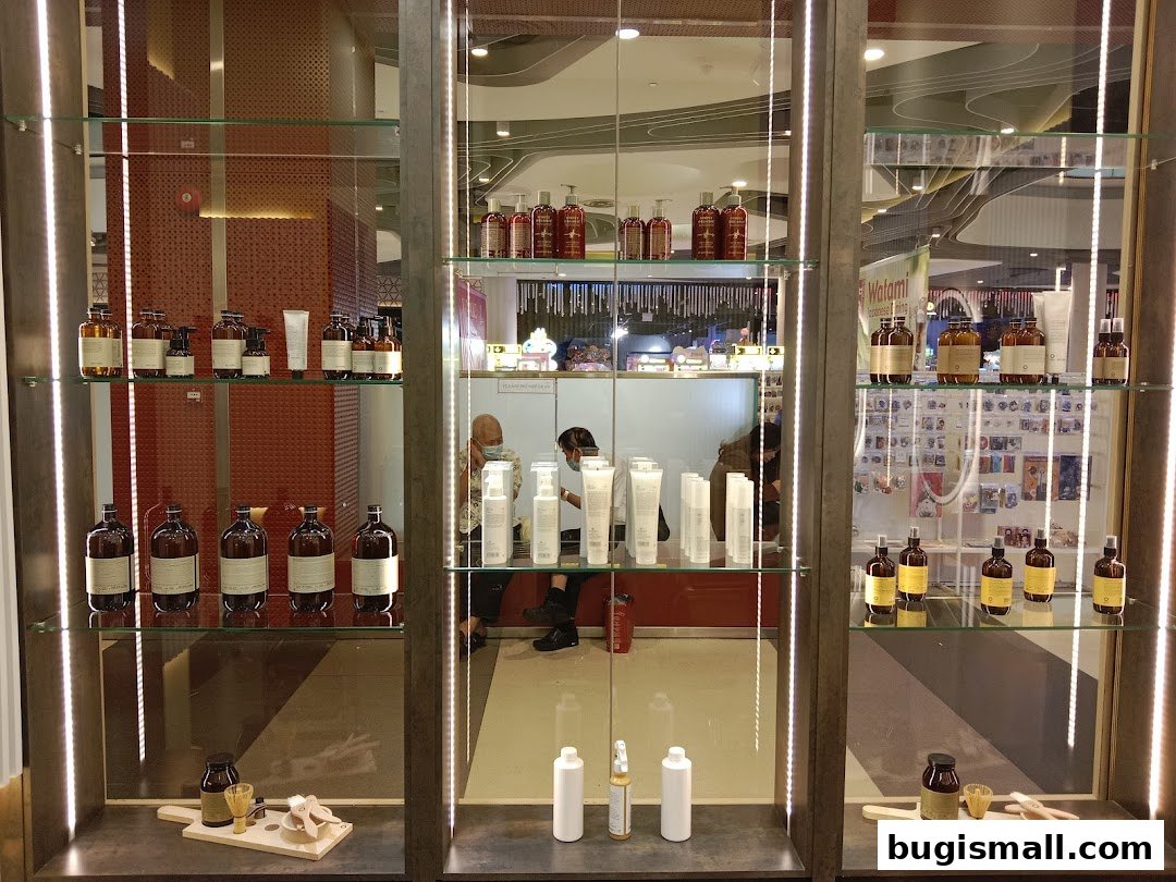 A display cabinet showcasing various bottles and products, with people visible in the background.