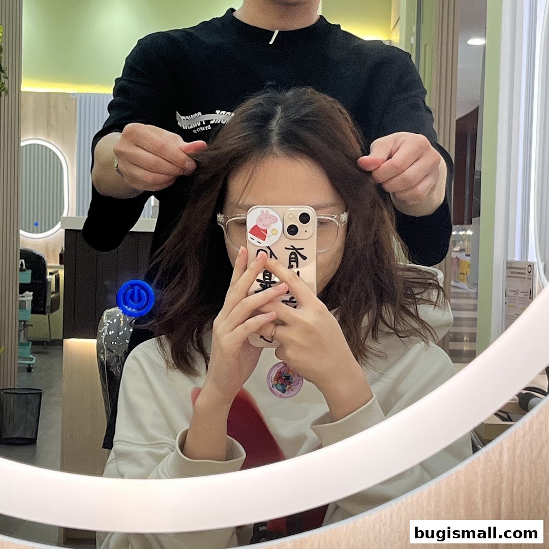 A person is getting their hair styled by a hairdresser in a salon.