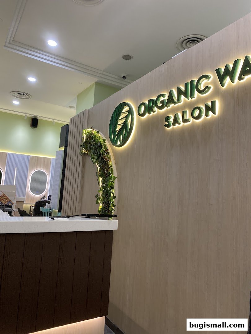 Interior view of Organic Way Salon with a reception desk and illuminated logo.