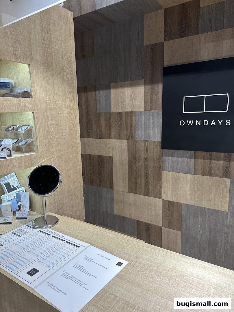 Interior shot of an OWNDAYS shop with a counter, display shelves, and branding.