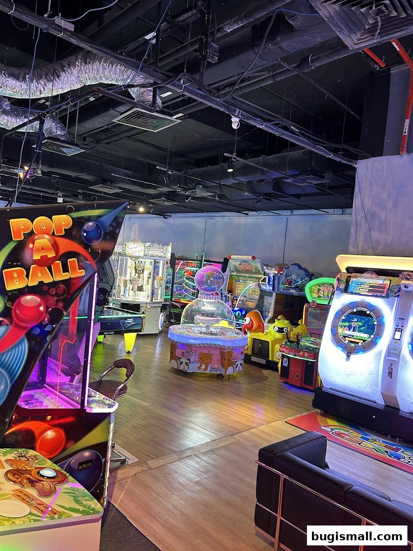 An interior view of an arcade with various colorful game machines and seating.