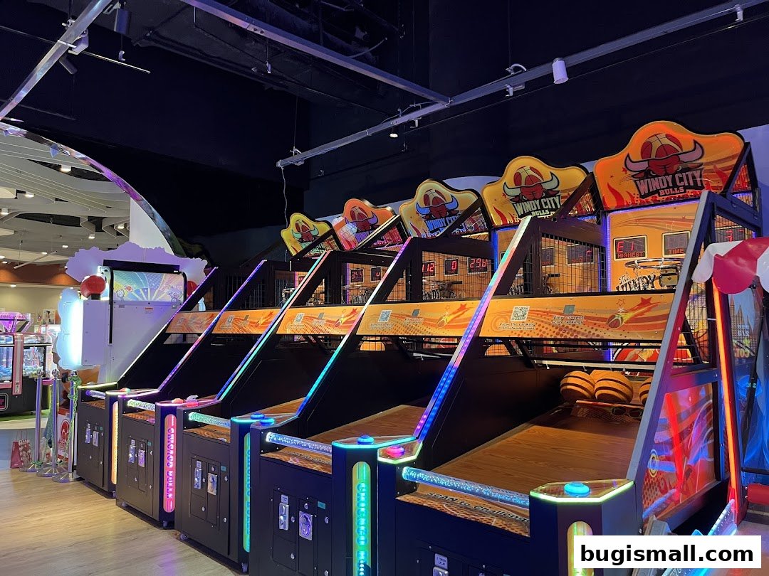 Row of illuminated arcade basketball games with colorful lights and digital scoreboards.