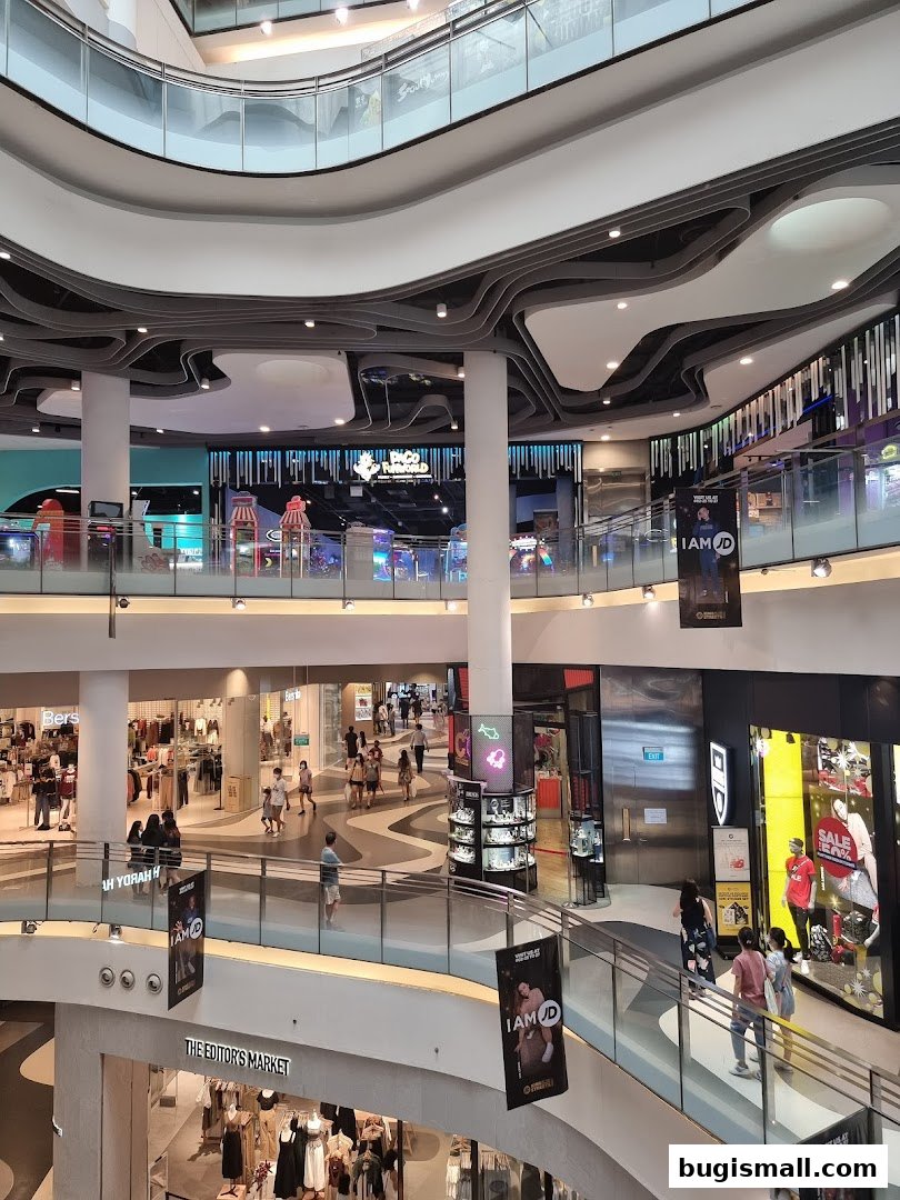 Interior view of a multi-level shopping mall with various shops and escalators.