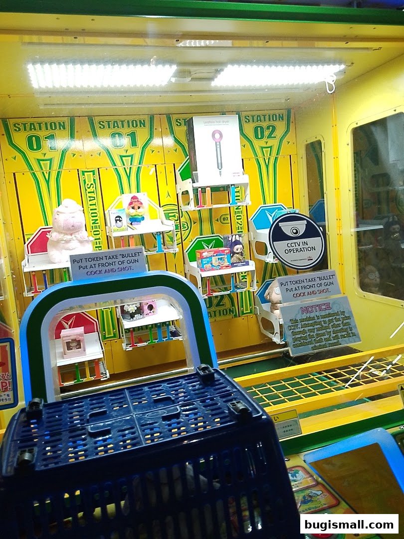 A claw machine game with prizes displayed, including a Dyson hair dryer.