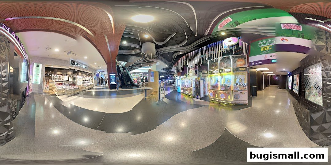A wide view of a shopping mall interior with shops, escalators, and arcade games.