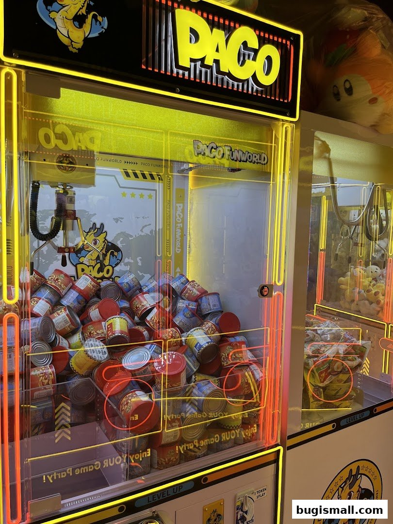 A brightly lit claw machine filled with cans, branded Paco FunWorld.