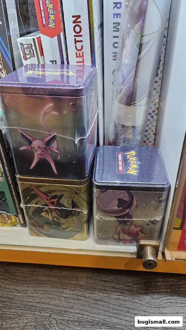Pokemon trading card game tins and collections displayed on a shelf.