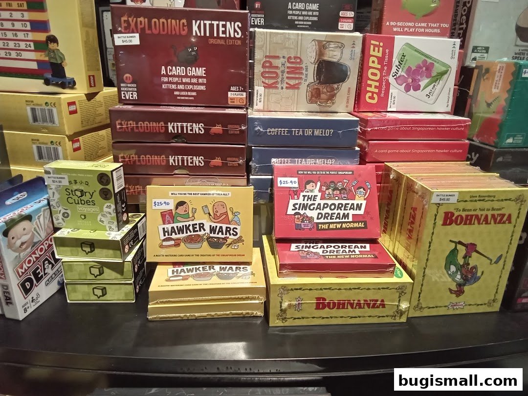 A display of various board games and card games, including Exploding Kittens and Hawker Wars.