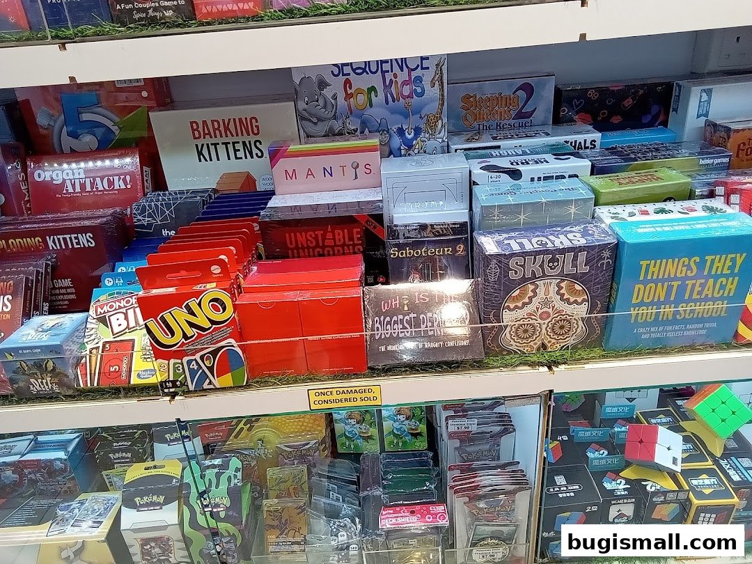 A display of various board games and card games, including popular titles like UNO and Exploding Kittens.