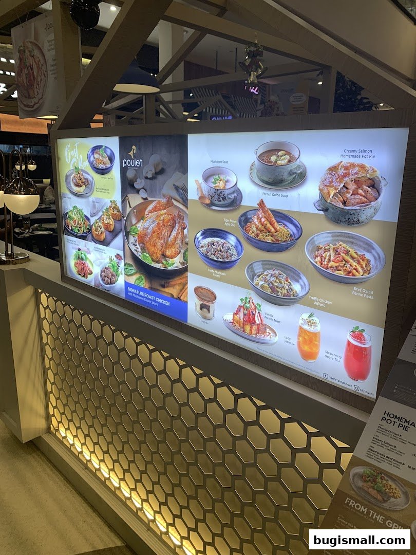A brightly lit menu board showcasing various dishes and drinks from Poulet restaurant.